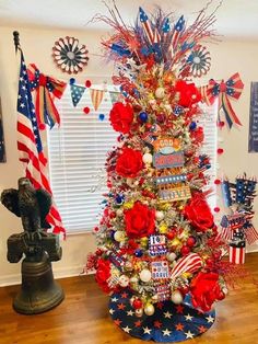 a patriotic christmas tree decorated with red, white and blue decorations in the shape of american flags