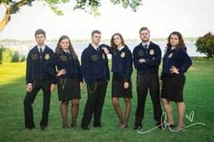 a group of young people standing next to each other on top of a lush green field