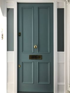 a blue front door with two brass handles on it's sides and the bottom panel is painted white