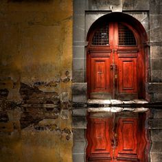 a red door is reflected in the water