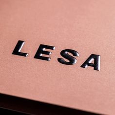 the word lesa written in black on a pink surface