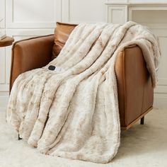 a brown leather chair with a white blanket on it