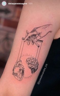 a woman's arm with a tattoo on it that has an image of two hands holding