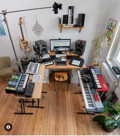 a room filled with musical instruments and sound equipment on top of a wooden floor next to a window