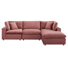 a pink sectional couch with pillows on it