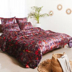 a bedroom with a bed, wicker basket and potted plant on the floor