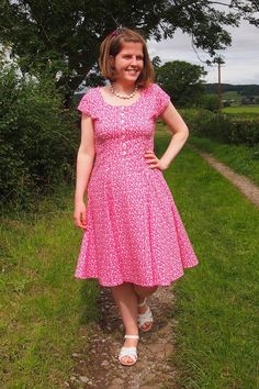 a woman in a pink dress standing on a path