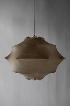 a light fixture hanging from a ceiling in a gray room with white walls and flooring