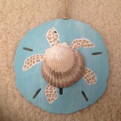 a sea shell is attached to the side of a blue plaque with a turtle on it