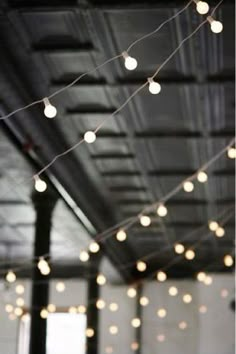 some lights are hanging from the ceiling in an empty room