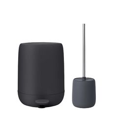 a black and gray object next to a toothbrush holder on a white background,