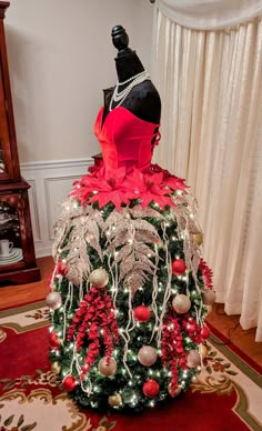 a mannequin is dressed up as a christmas tree with red and gold decorations