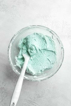 a bowl filled with green paste next to a spoon