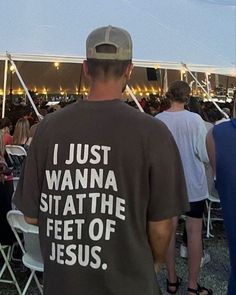 a man standing in front of a tent while wearing a t - shirt that says i just wanna state the feet of jesus