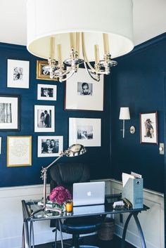 a laptop computer sitting on top of a desk in front of a chandelier