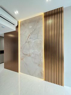 an empty room with marble walls and gold trim on the wall, along with white flooring