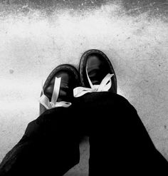 black and white photograph of someone's feet wearing shoes