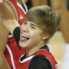 a young boy making a funny face while playing basketball