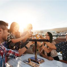 group of people toasting with beer at outdoor table