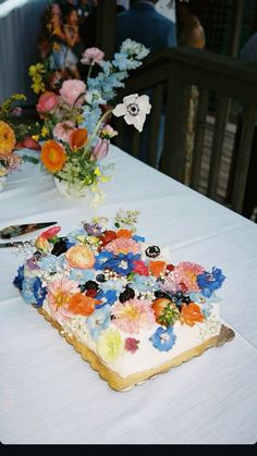 a table topped with a cake covered in frosting and flowers