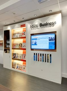 the inside of a book store with many books on shelves and a large television mounted to the wall