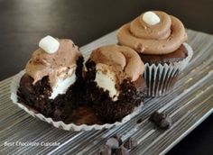 two cupcakes with chocolate frosting and marshmallows are on a plate