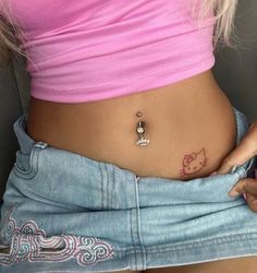 a woman with a hello kitty tattoo on her stomach holding a cell phone in her hand