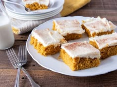 four pieces of pumpkin cake on a plate with silverware next to it and two forks