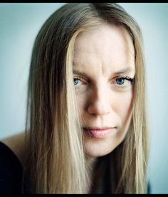 a woman with long blonde hair and blue eyes looks at the camera while posing for a photo