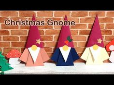 paper christmas gnomes are lined up in front of a brick wall with the words christmas gnome on it