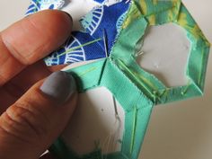 someone is peeling fabric off of an origami piece