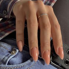 a woman's hand holding onto her jeans pocket and wearing a ring on it