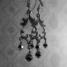 Romantic jet black Swarovski crystals dangling from Victorian style chandelier filigree. The filigree and ear wires are raw brass that I hand-oxidize to the Gothic inspired black finish.---------------------------------------------------------------------------------------------Dimensions and details:- Largest beads measure 6mm in diameter- From the top of the ear wires to the bottom of the earrings, they measure approximately 2 1/8 inches (5 4mm)- Filigree is USA-made raw brass, which I have ag Gothic Chandelier, Black Metal Jewelry, Victorian Gothic Jewelry, Black Crystal Earrings, Crystal Chandelier Earrings, Dark Romantic, Gothic Earrings, Moody Wedding, The Gothic