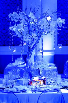 an elegant centerpiece with flowers and candles is displayed on a table at a wedding reception