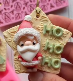 a hand holding a christmas ornament with santa clause on it