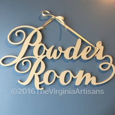 a wooden sign that says powder room hanging on the wall in front of a blue wall