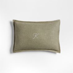 an embroidered monogrammed pillow on a white background