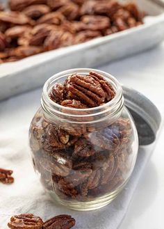 a glass jar filled with pecans sitting on top of a table