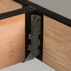 a close up view of a wooden door with metal hinges and wood grain