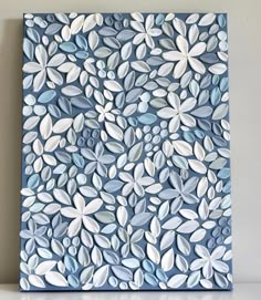 a blue and white painting with leaves on it