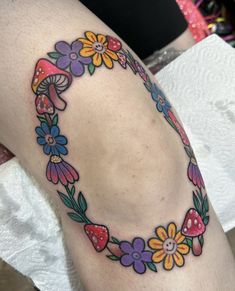 a woman's thigh with flowers and mushrooms on it