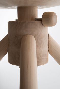 a close up of a wooden chair with wood legs and an object in the background