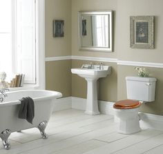 a bath room with a toilet a sink and a bath tub next to a window