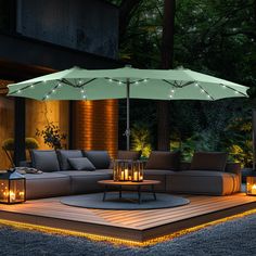 an outdoor living area lit up with candles and lights, including an umbrella over the couch