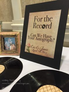 an old record is on the table next to two framed records and a sign that says, for the record can we have your autograph?