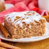 a close up of a piece of cake on a plate with cinnamon sticks next to it