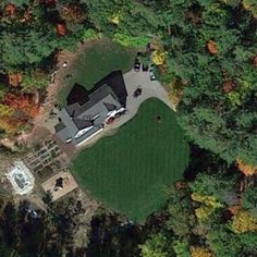 an aerial view of a house in the middle of some trees with fall foliage around it