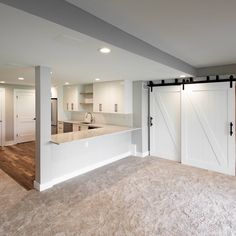 an empty kitchen and living room with sliding doors