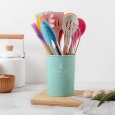 a cup filled with lots of colorful utensils