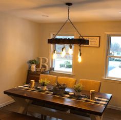 a dining room table with chairs and lights hanging from it's centerpieces